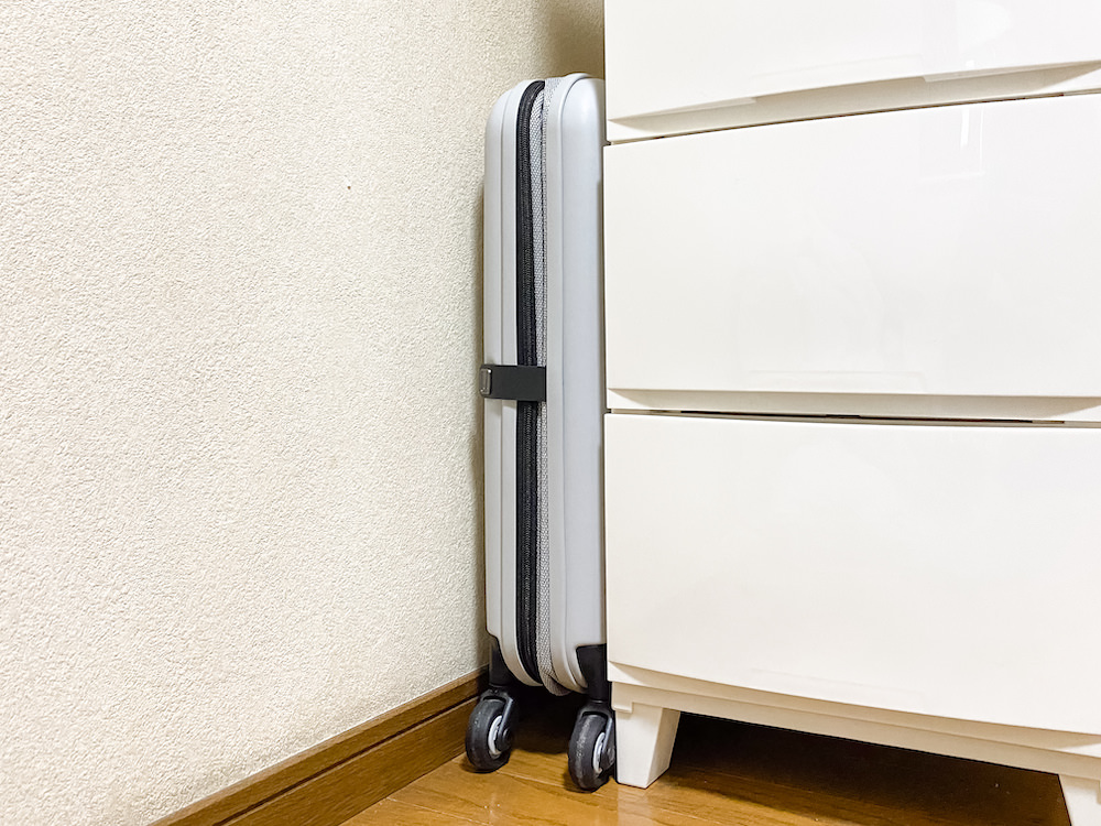 JOLLYING(ジョーイング)の折りたたみスーツケース「PEBBLE(ペブル)」を家具の隙間に収納している様子