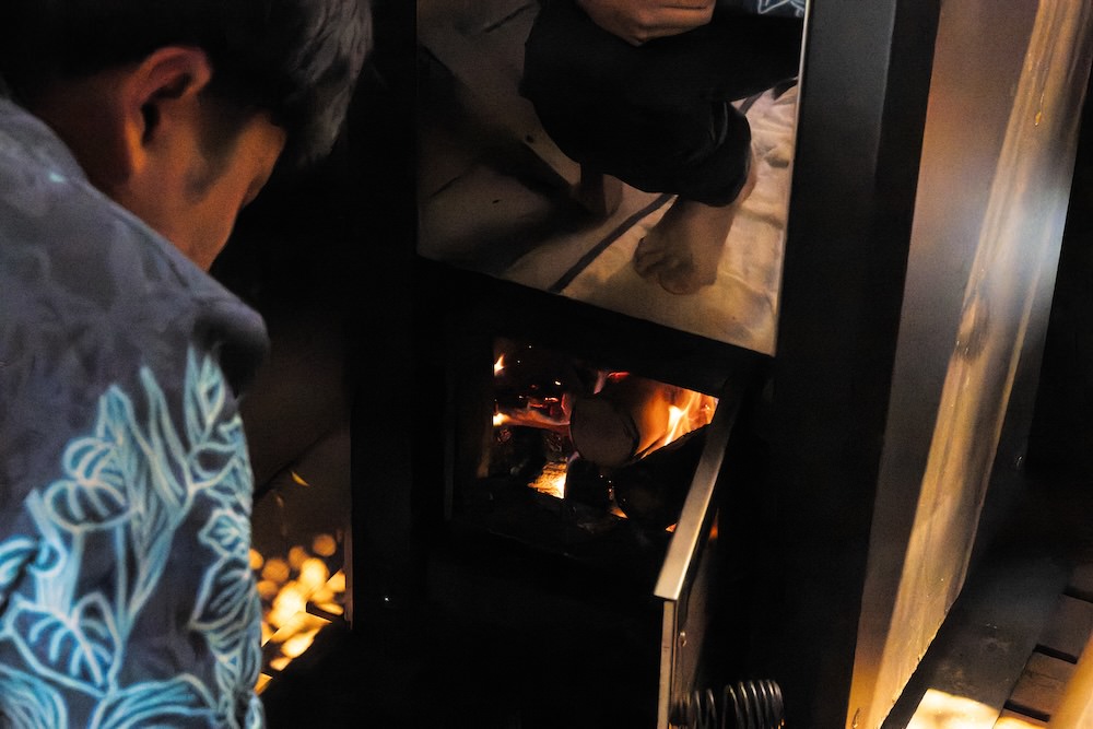 薪をくべるスタッフ