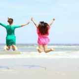 ビーチリゾートでジャンプしている二人の女性