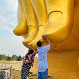 巨大仏像ルアンポーヤイの指に触れる人々