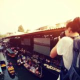 水上マーケットを撮影している女性旅行者